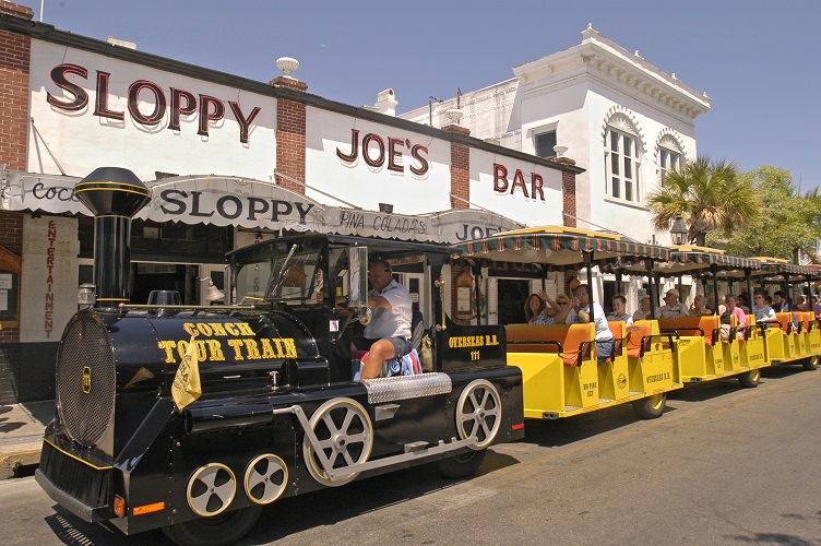 Visitors in Key West, Fla., ride the Conch Tour Train as it passes in front of Sloppy Joe's Bar, former watering hole of author Ernest Hemingway. The faux train and Old Town Trolley are two of the island's primary motorized tour operations. Key West is the southernmost city in the continental United States.  Photo by Bob Krist/Florida Keys News Bureau